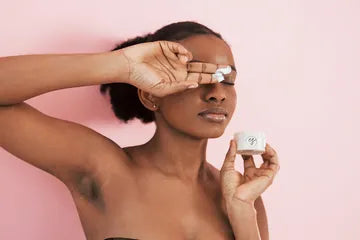 A woman applying a Cota Skin collagen eye mask